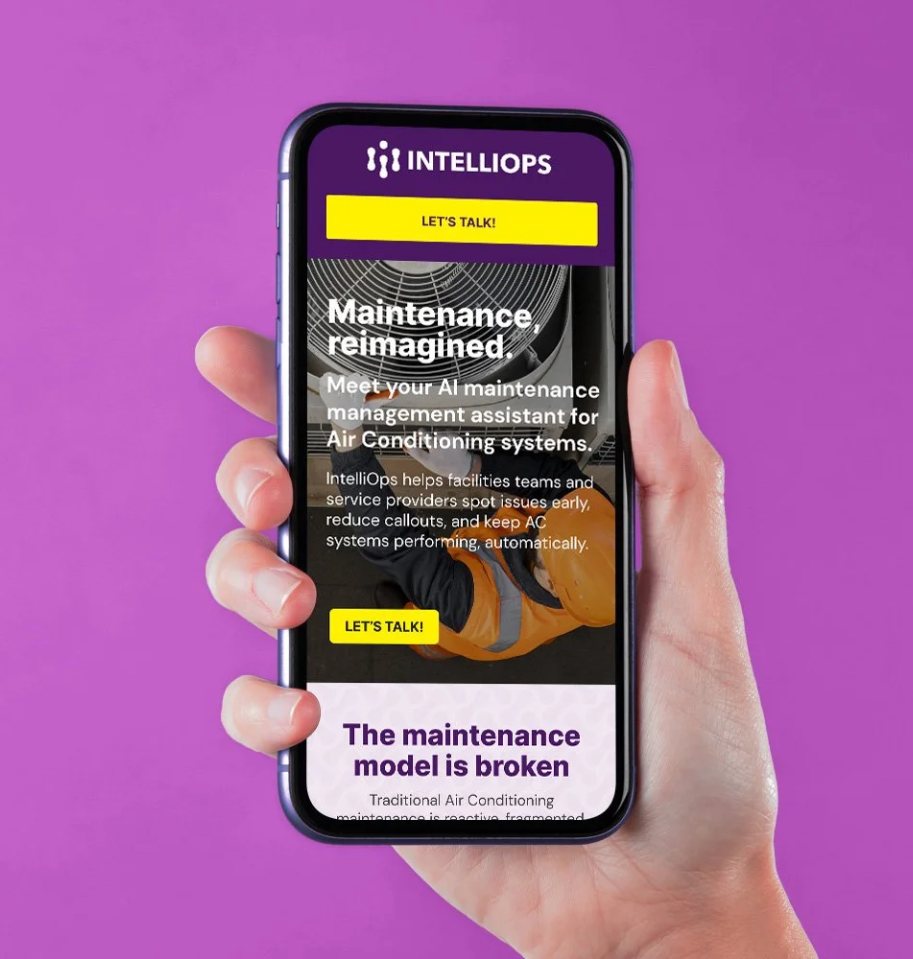 Hand holding a phone showing the IntelliOps mobile site